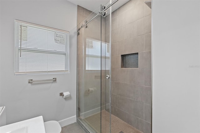 full bath featuring a stall shower, toilet, and baseboards