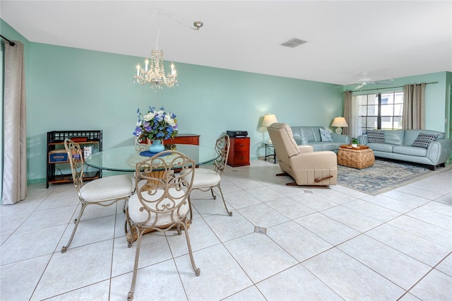 dining area with light tile patterned floors, ceiling fan with notable chandelier, and visible vents