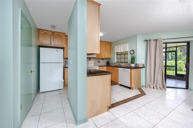 kitchen with light tile patterned floors, white appliances, visible vents, decorative backsplash, and dark countertops