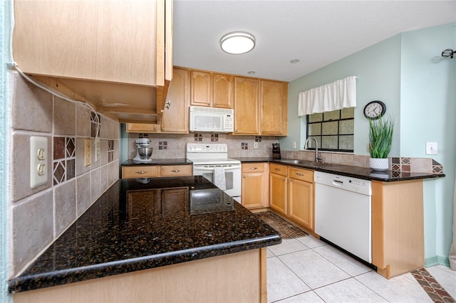 kitchen with white appliances, a sink, backsplash, and light brown cabinetry