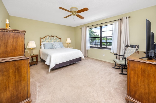 bedroom featuring light colored carpet, ceiling fan, and baseboards