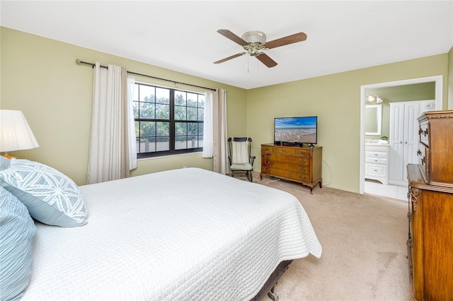 bedroom featuring connected bathroom, a ceiling fan, and light colored carpet