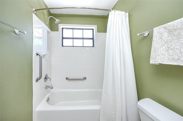 full bath featuring a textured wall, shower / bath combo, and toilet