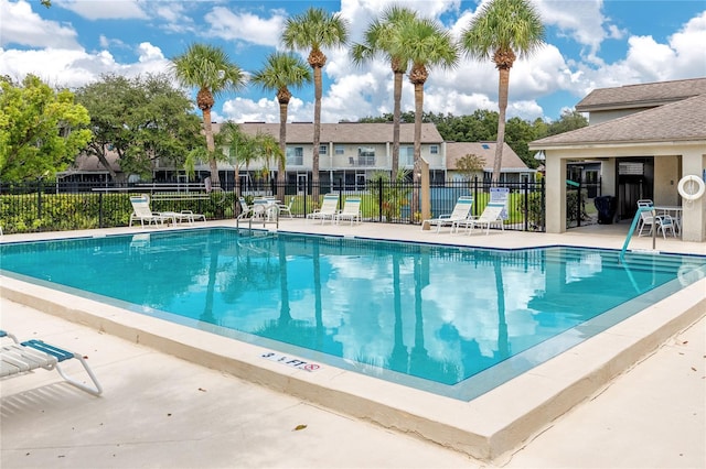 view of pool featuring a patio area, a residential view, and fence