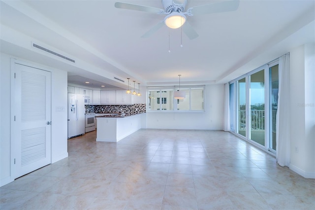 unfurnished living room featuring ceiling fan and sink