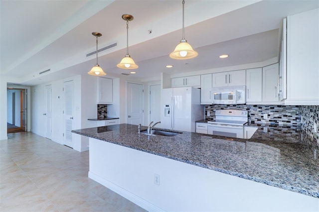 kitchen with sink, white appliances, dark stone counters, and white cabinets