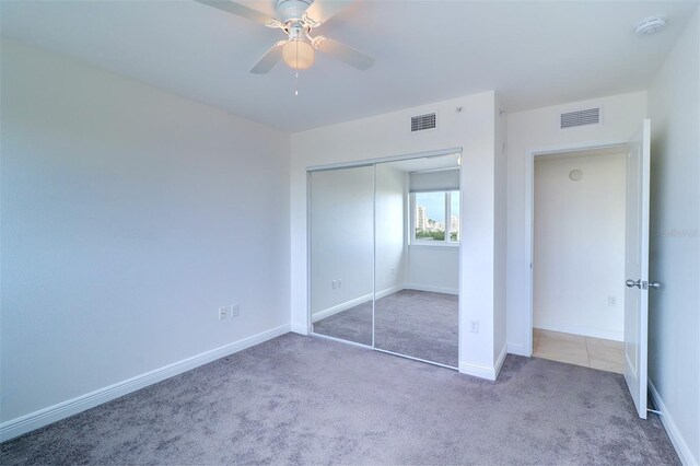 unfurnished bedroom featuring carpet, ceiling fan, and a closet