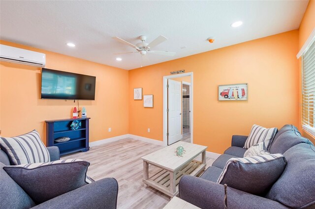 living room featuring ceiling fan, light hardwood / wood-style floors, and a wall mounted AC