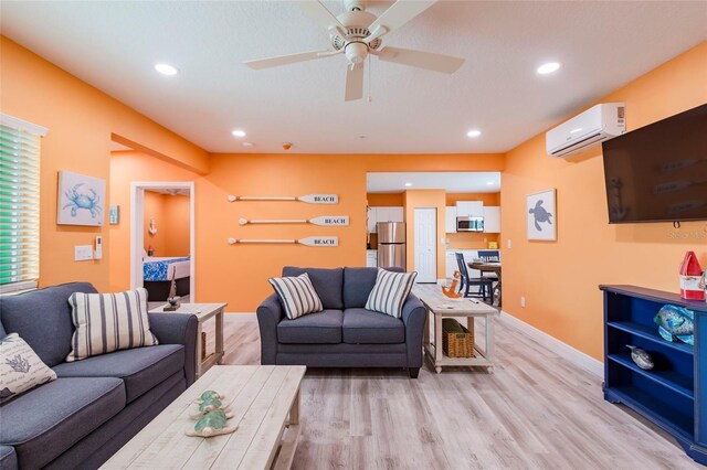 living room with light hardwood / wood-style floors, ceiling fan, and a wall unit AC