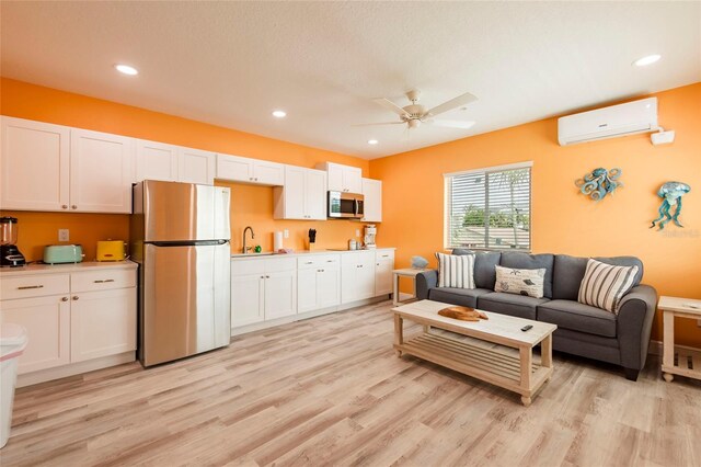 living room featuring sink, ceiling fan, light wood-type flooring, and a wall unit AC