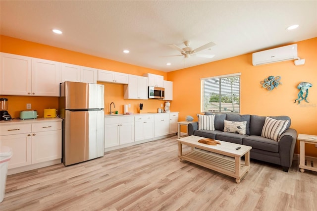 living area with recessed lighting, light wood-style flooring, a ceiling fan, and a wall mounted AC