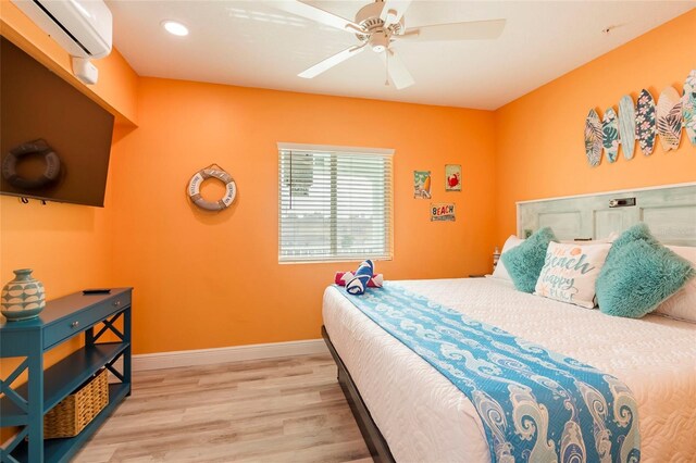 bedroom featuring light hardwood / wood-style flooring, ceiling fan, and an AC wall unit