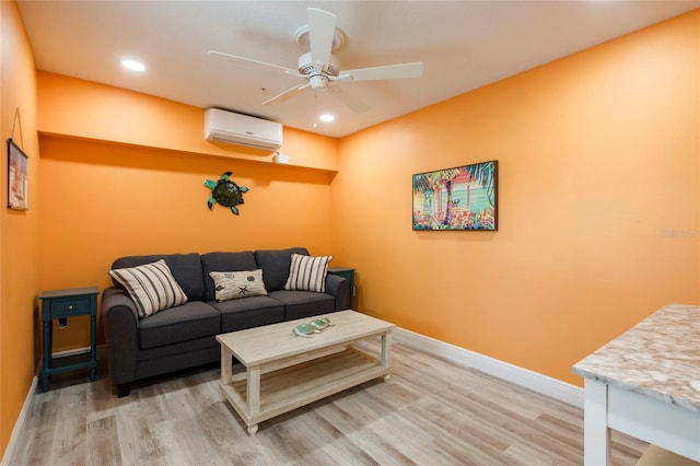 living room with ceiling fan, a wall unit AC, and light hardwood / wood-style floors