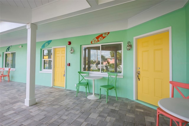 property entrance featuring a patio area and stucco siding