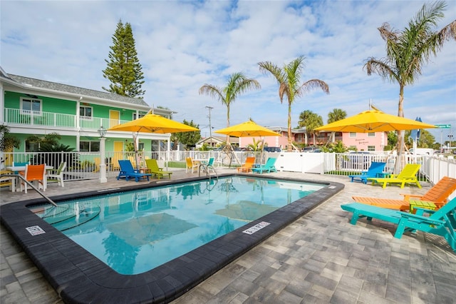 pool with a patio and fence