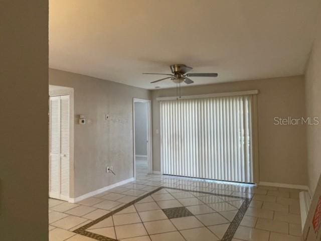 tiled spare room with ceiling fan