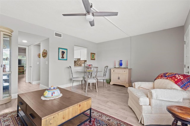 living room featuring ceiling fan and light hardwood / wood-style flooring