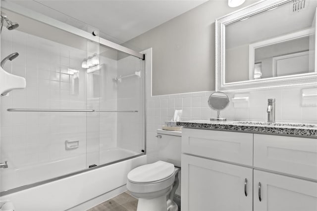 full bathroom with hardwood / wood-style floors, vanity, tasteful backsplash, tile walls, and toilet