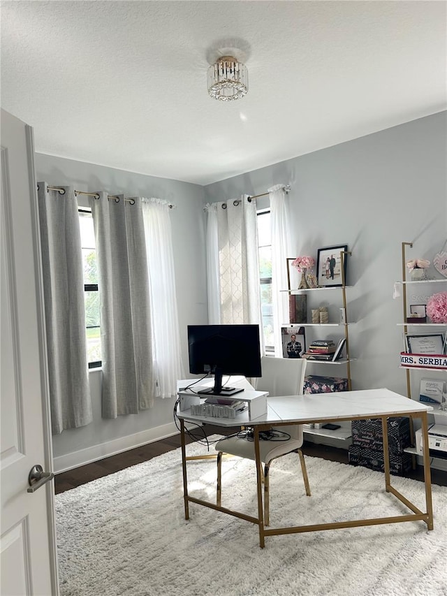 home office with plenty of natural light, wood finished floors, and baseboards