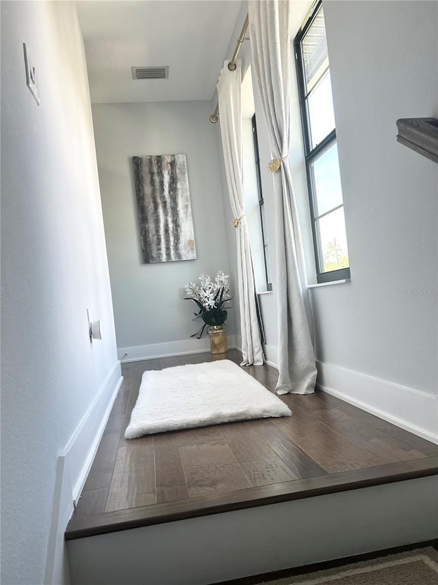 interior space featuring baseboards, visible vents, and wood finished floors