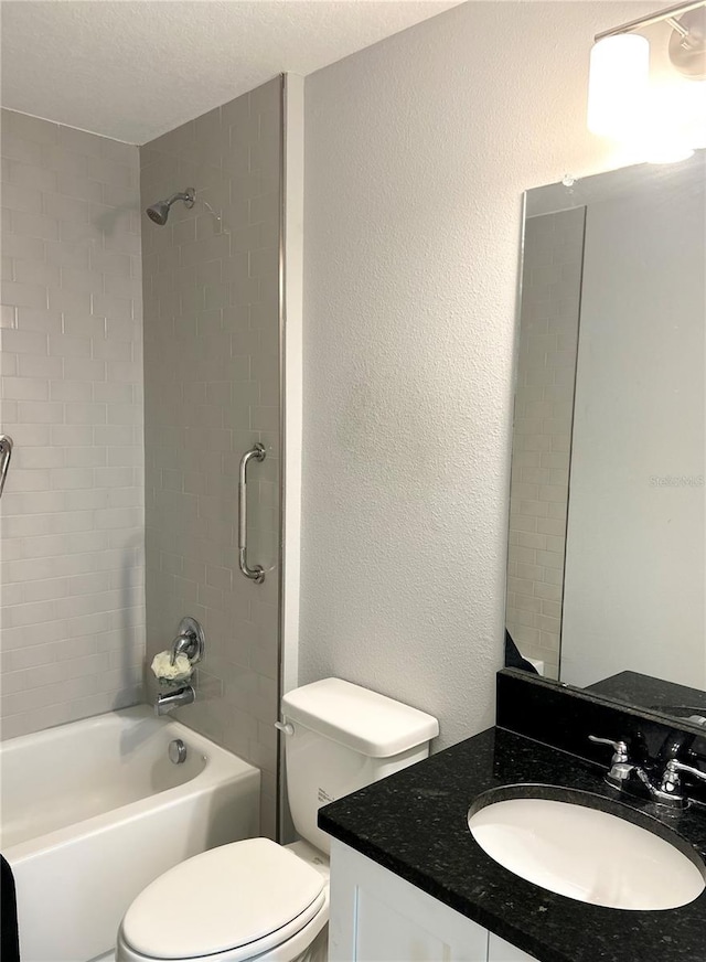 full bathroom with a textured wall, vanity, toilet, and shower / bathtub combination