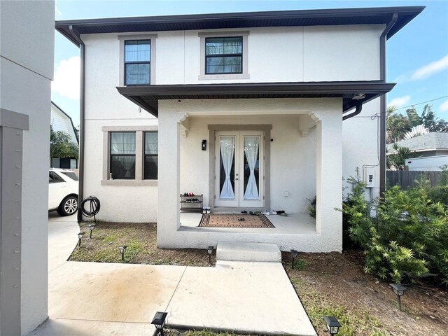 entrance to property featuring french doors and stucco siding