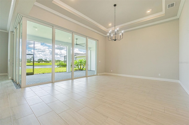 unfurnished room with a tray ceiling, crown molding, and a notable chandelier