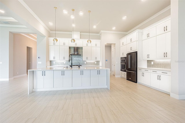 kitchen with white cabinetry, hanging light fixtures, wall chimney range hood, and appliances with stainless steel finishes