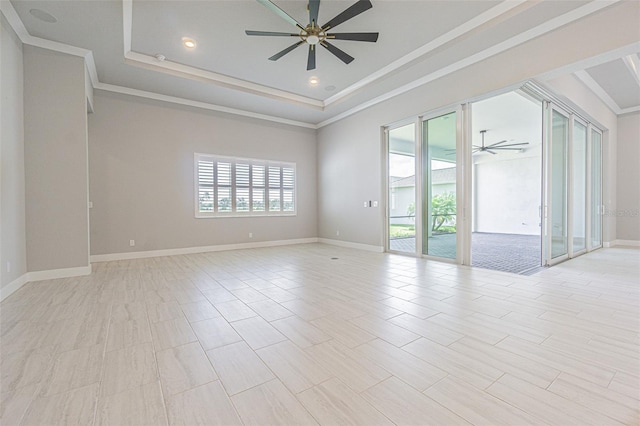 empty room with a tray ceiling, ceiling fan, and crown molding