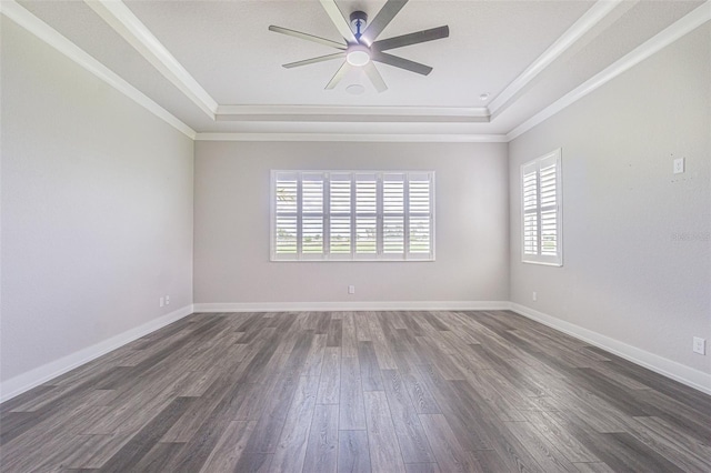 unfurnished room with a raised ceiling, dark hardwood / wood-style flooring, crown molding, and a healthy amount of sunlight