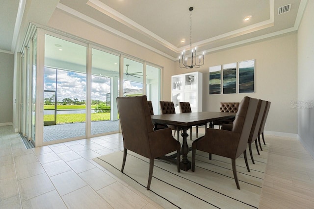 dining area with a chandelier, a raised ceiling, and crown molding