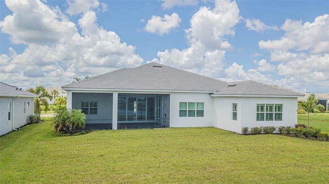 rear view of house with a sunroom and a yard