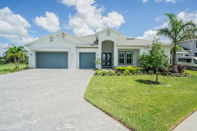 view of front of home featuring a front lawn, a garage, and french doors