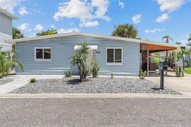 manufactured / mobile home with a carport and concrete driveway