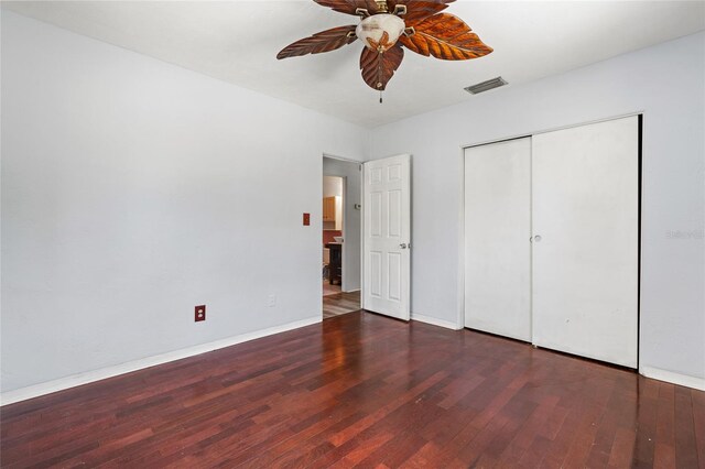 unfurnished bedroom with a closet, ceiling fan, and dark hardwood / wood-style flooring