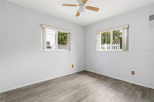 spare room featuring a ceiling fan, baseboards, and wood finished floors