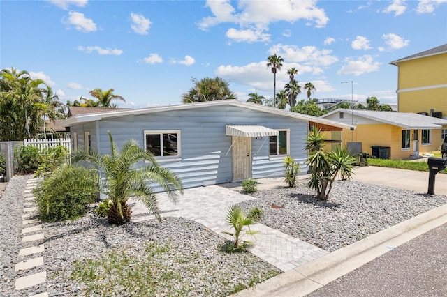 view of front of home featuring cooling unit, driveway, a patio, and fence