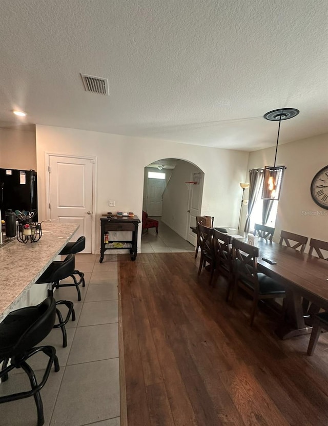 dining room with hardwood / wood-style flooring and a textured ceiling