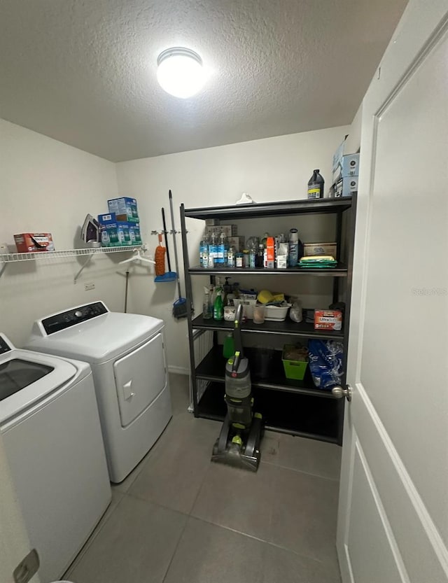 laundry area with washer and dryer, light tile patterned floors, and a textured ceiling