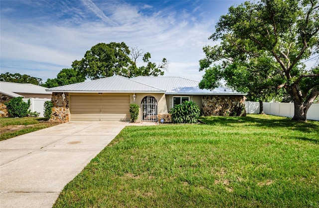 ranch-style home featuring a garage and a front lawn