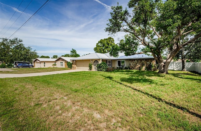 ranch-style home featuring an attached garage, fence, a front lawn, and concrete driveway