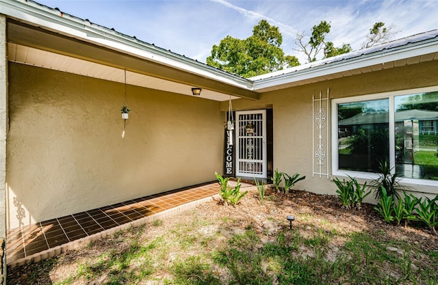 doorway to property featuring stucco siding