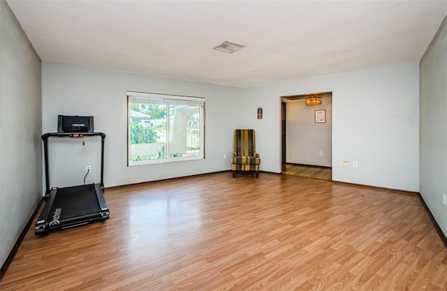 workout room featuring light wood-style flooring and visible vents