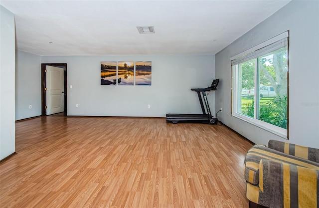 workout area with visible vents and light wood-style floors