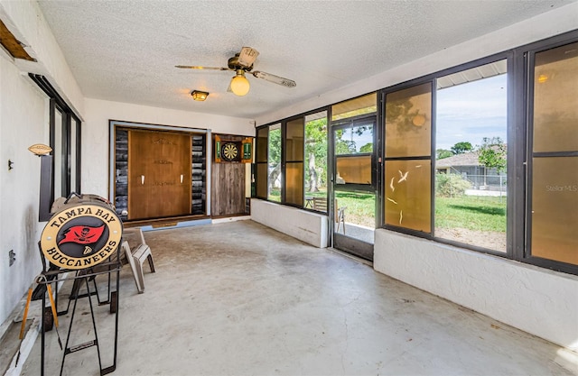 unfurnished sunroom with a ceiling fan