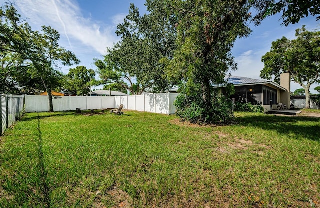 view of yard with a sunroom and a fenced backyard