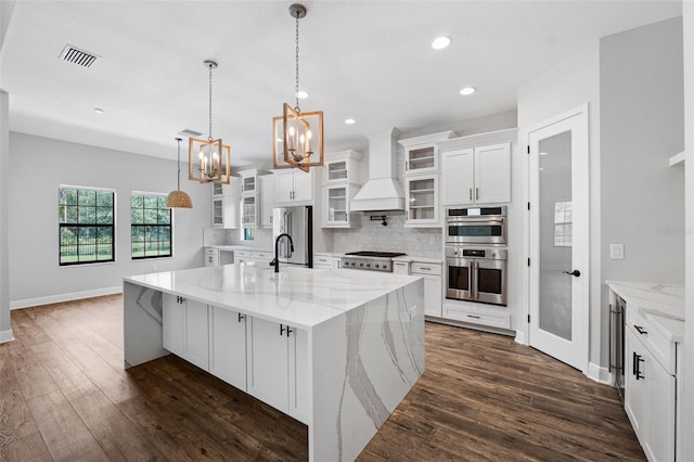 kitchen featuring stainless steel appliances, white cabinetry, a large island, dark hardwood / wood-style floors, and custom exhaust hood