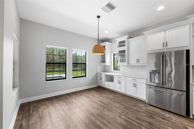 kitchen with dark wood-type flooring, high quality fridge, pendant lighting, and white cabinets