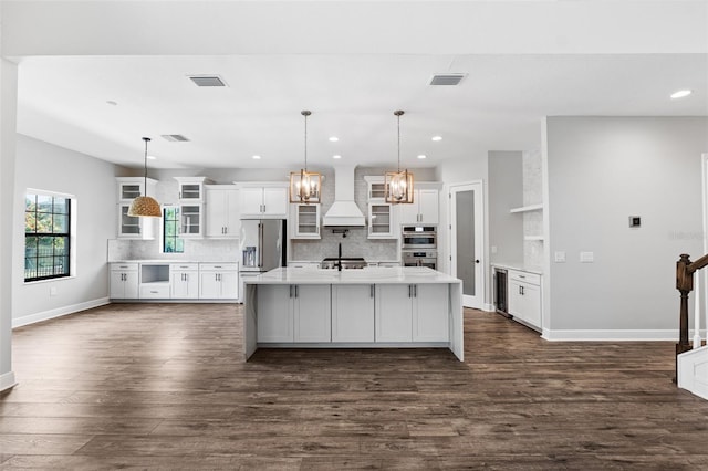 kitchen with white cabinetry, pendant lighting, appliances with stainless steel finishes, and custom exhaust hood