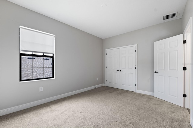 unfurnished bedroom with a closet and carpet flooring